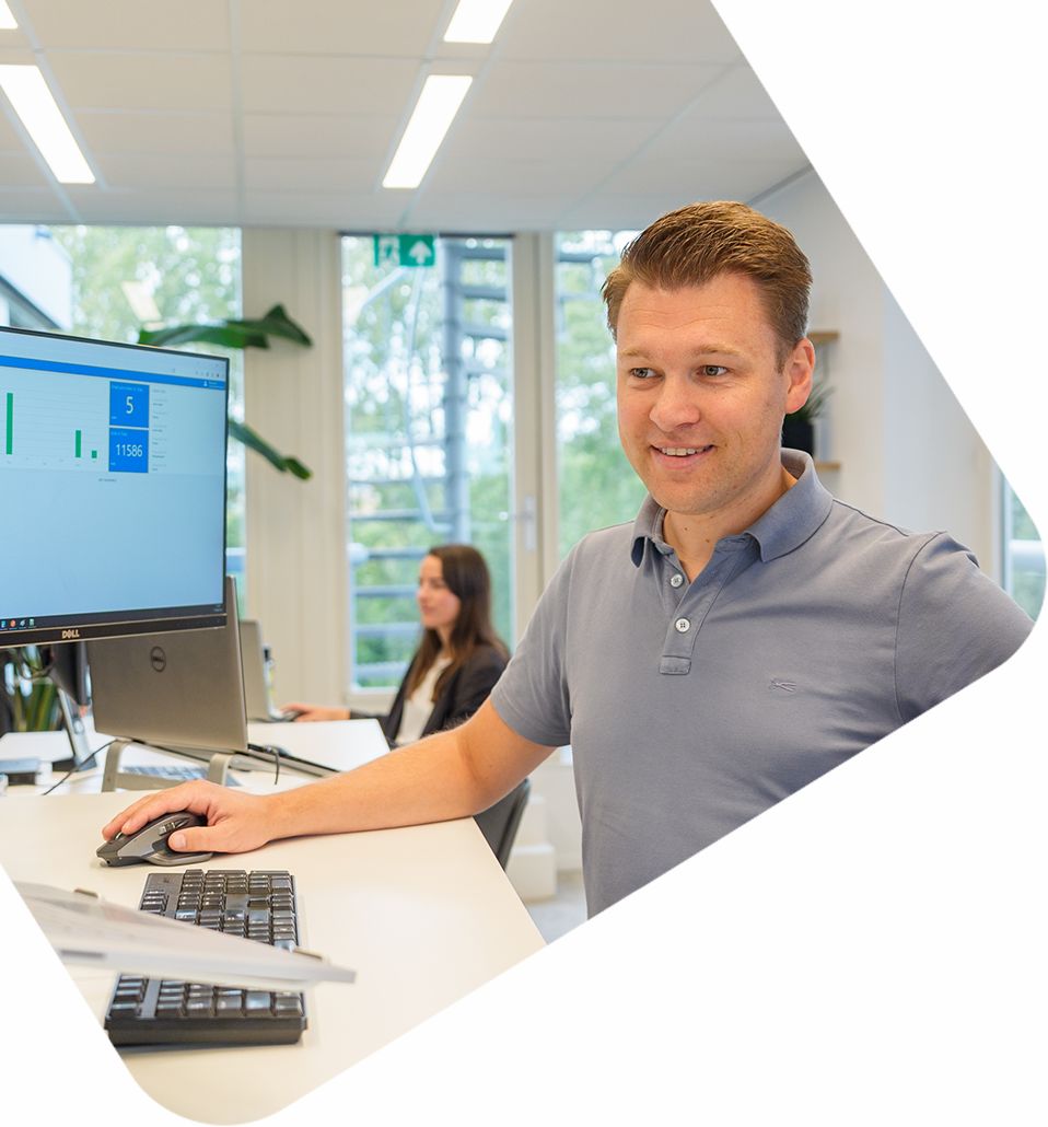 Medewerker bekijkt B2B e-commerce dashboard op computerscherm in moderne kantooromgeving