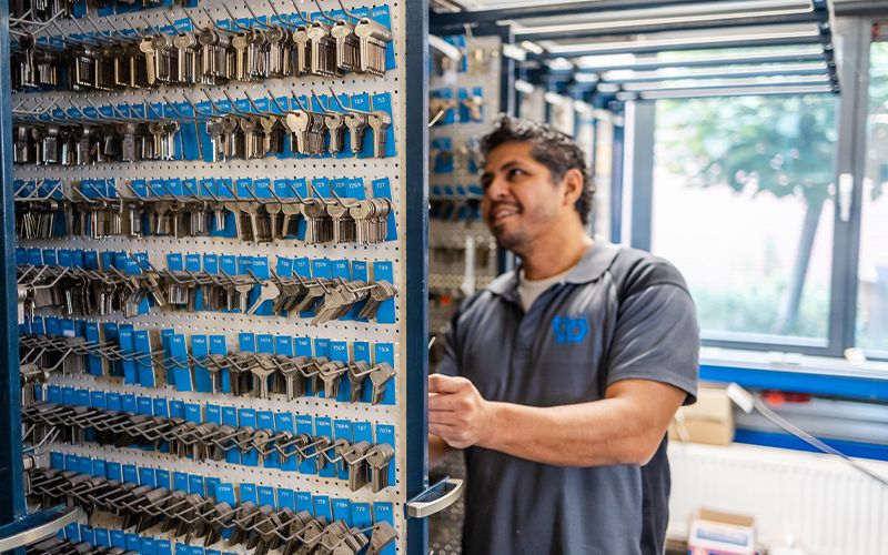 Medewerker selecteert sleutel uit uitgebreid sleutelsysteem bij Van Buuren