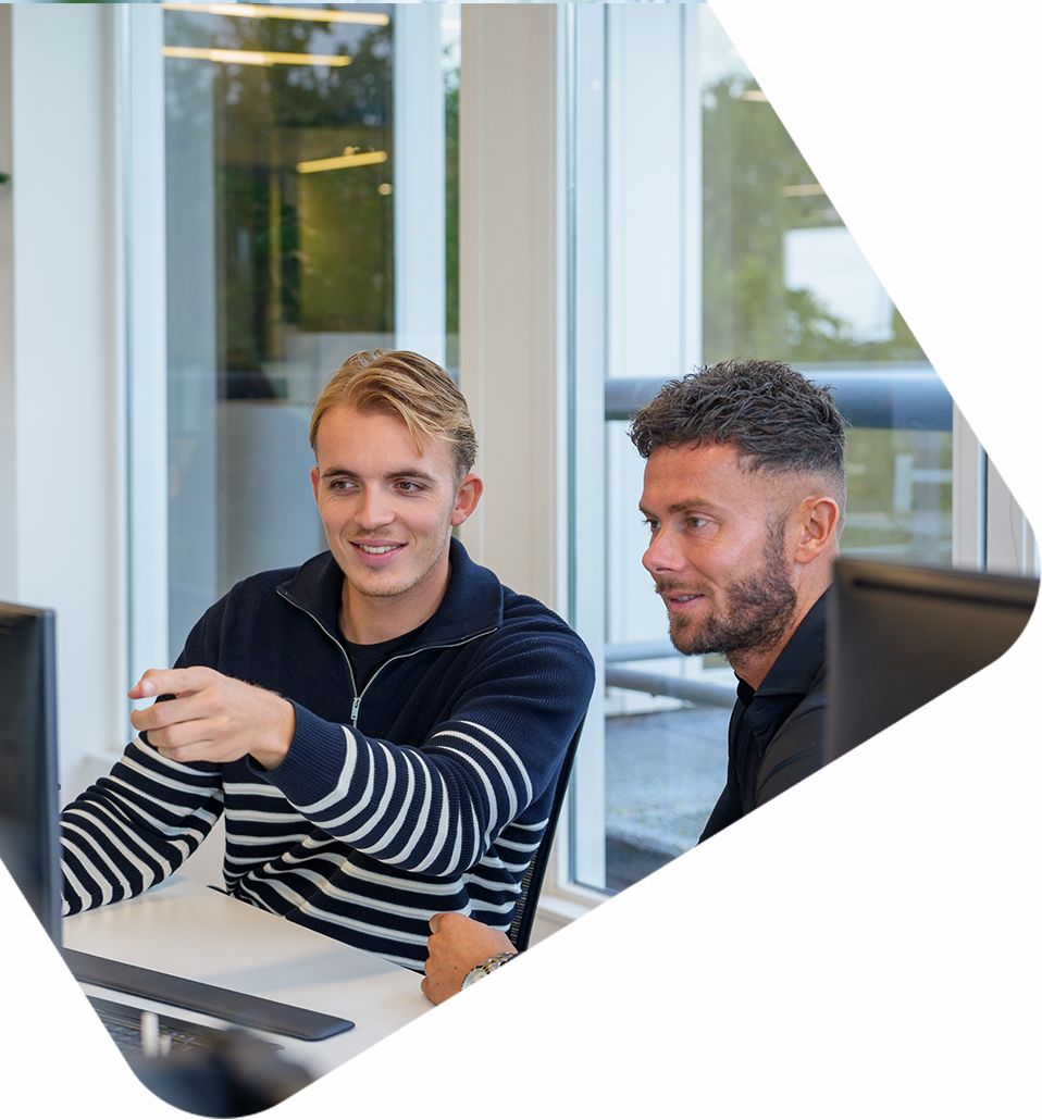 Twee mannen bespreken feedmarketing achter beeldscherm bij Bluedesk